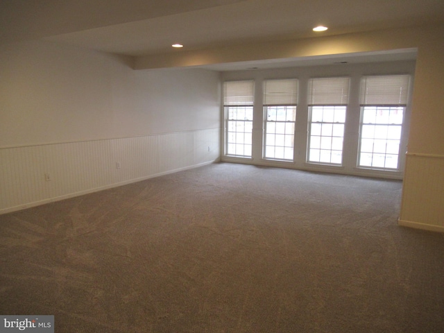 unfurnished room with dark colored carpet