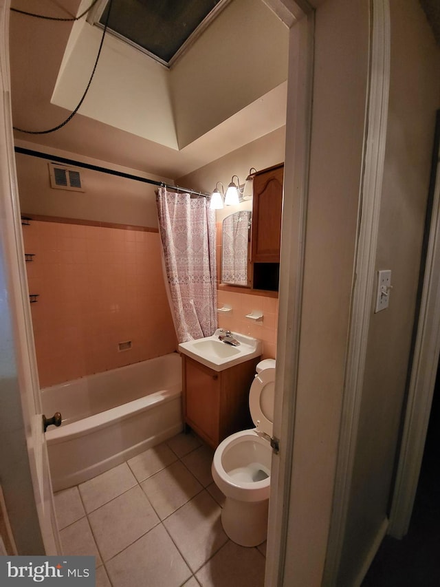 full bathroom featuring toilet, vanity, shower / bathtub combination with curtain, and tile patterned flooring