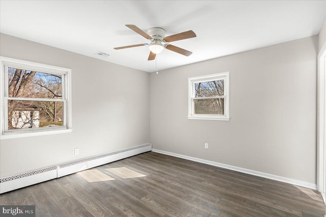 empty room featuring baseboards, visible vents, ceiling fan, wood finished floors, and a baseboard heating unit