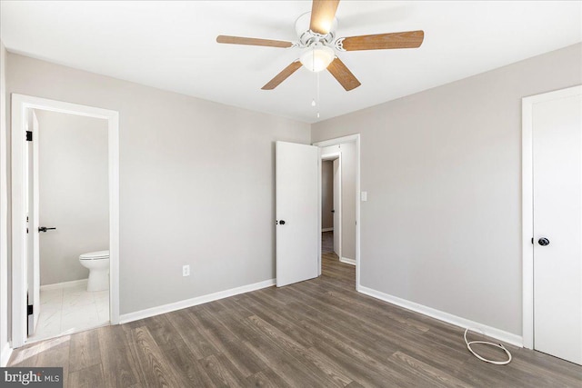 unfurnished bedroom with ceiling fan, connected bathroom, baseboards, and wood finished floors