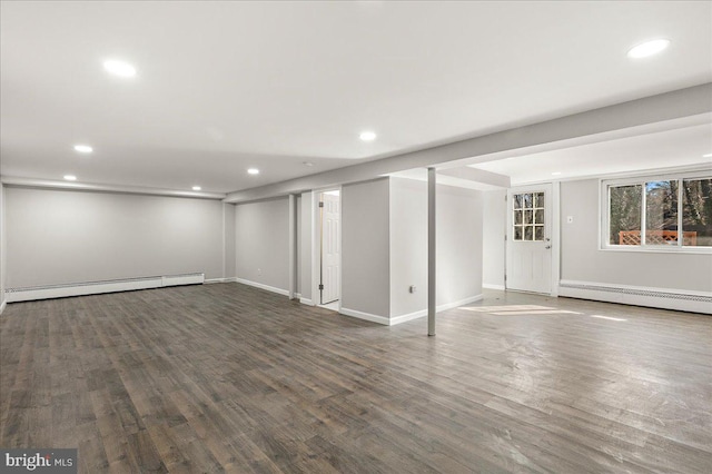 basement featuring recessed lighting, baseboard heating, and wood finished floors