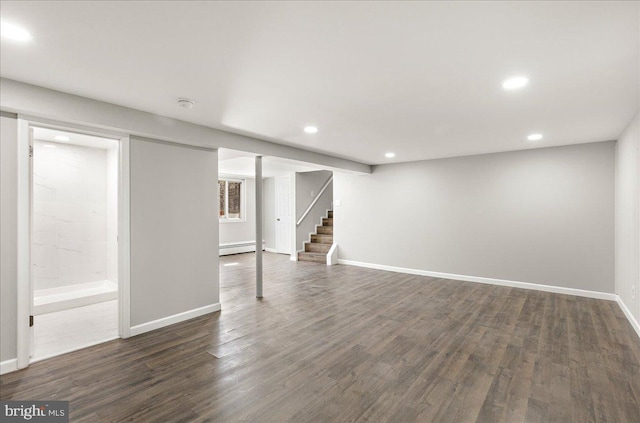 finished basement with dark wood-style floors, a baseboard radiator, recessed lighting, baseboards, and stairs