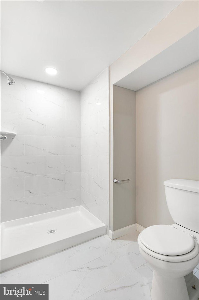 full bathroom featuring a stall shower, marble finish floor, baseboards, and toilet