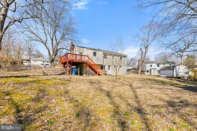 rear view of house featuring a chimney, stairway, fence, and a wooden deck