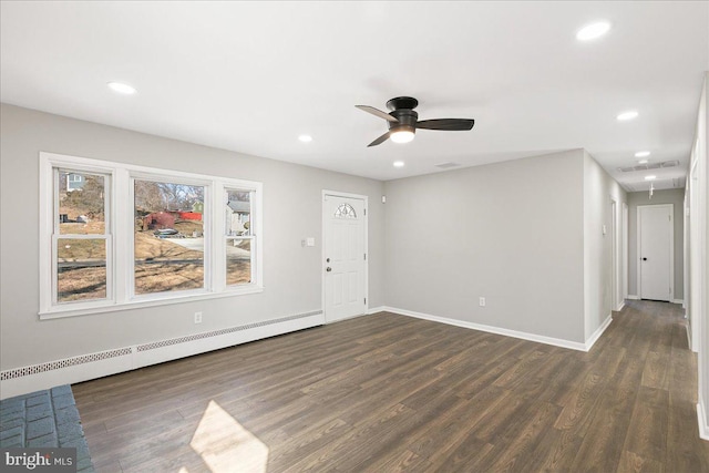 interior space with a baseboard heating unit, attic access, visible vents, and dark wood-type flooring