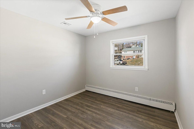 spare room featuring dark wood-type flooring, baseboards, baseboard heating, and a ceiling fan