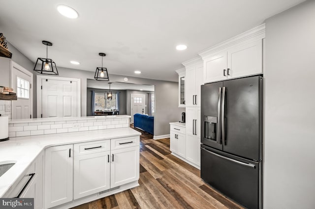 kitchen featuring white cabinets, pendant lighting, stainless steel fridge, and dark hardwood / wood-style flooring