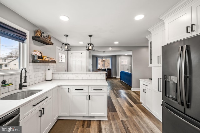 kitchen featuring sink, white cabinetry, decorative light fixtures, appliances with stainless steel finishes, and kitchen peninsula