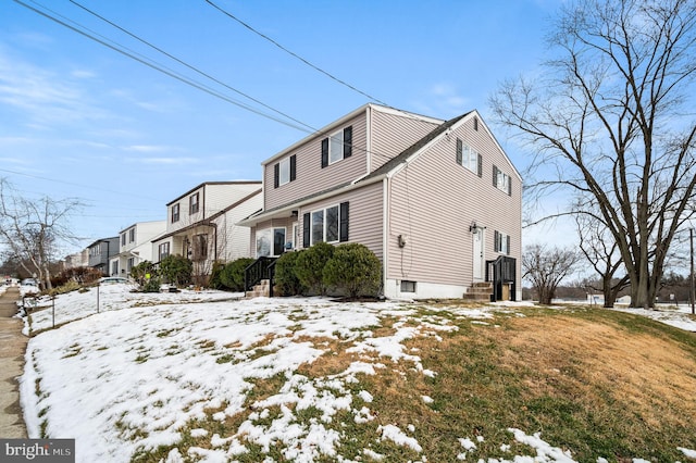 snow covered property with a lawn