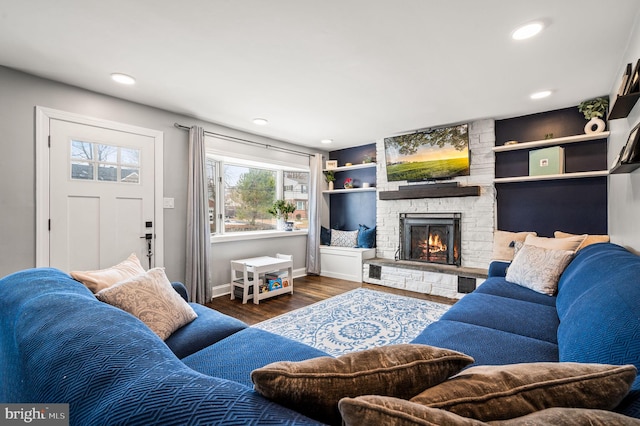 living room with a fireplace, built in features, and dark hardwood / wood-style floors