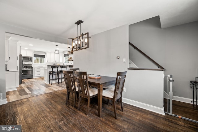 dining area featuring wood-type flooring and a chandelier