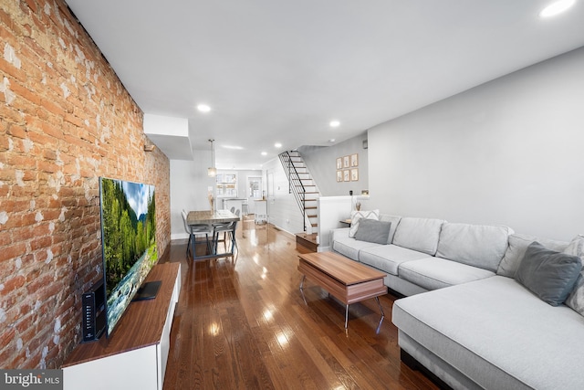 unfurnished living room with brick wall and hardwood / wood-style floors