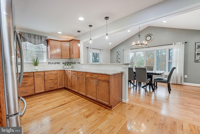 kitchen featuring light hardwood / wood-style flooring, stainless steel refrigerator, backsplash, light stone counters, and kitchen peninsula