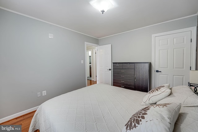 bedroom featuring crown molding and wood-type flooring