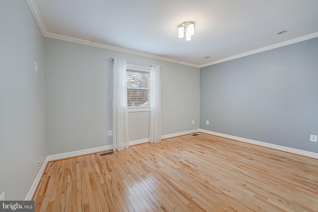 spare room with crown molding and light wood-type flooring