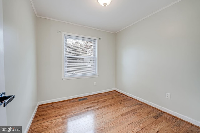 empty room featuring ornamental molding and light hardwood / wood-style floors