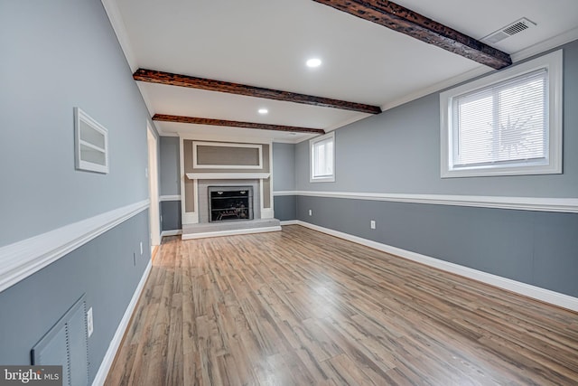 unfurnished living room with beamed ceiling and light hardwood / wood-style flooring