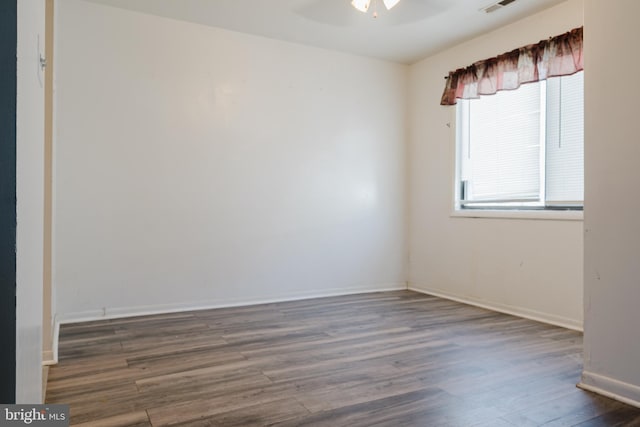 unfurnished room featuring ceiling fan, a healthy amount of sunlight, and dark hardwood / wood-style flooring