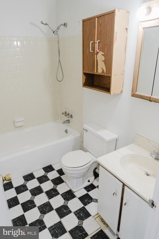 full bathroom with tiled shower / bath, vanity, and toilet