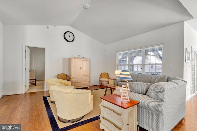 living room with light hardwood / wood-style flooring and vaulted ceiling