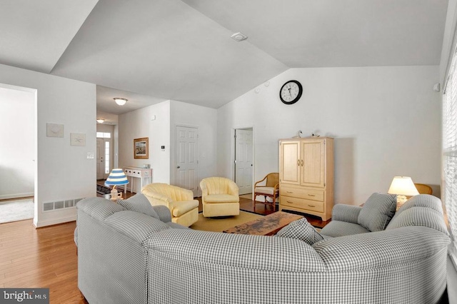 living room with vaulted ceiling and light wood-type flooring