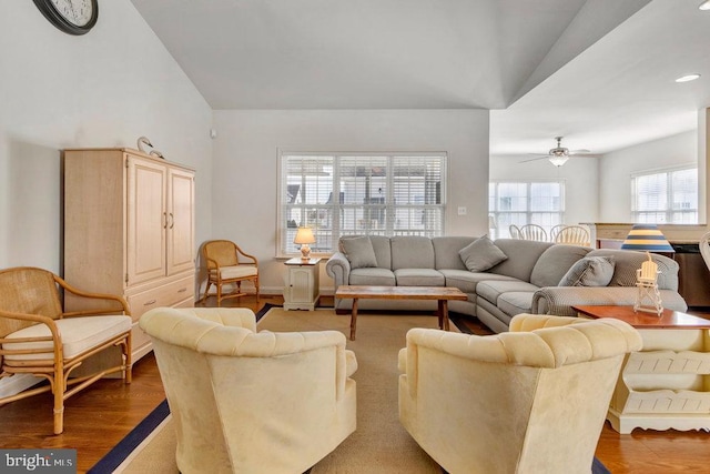 living room with ceiling fan, lofted ceiling, and light hardwood / wood-style flooring