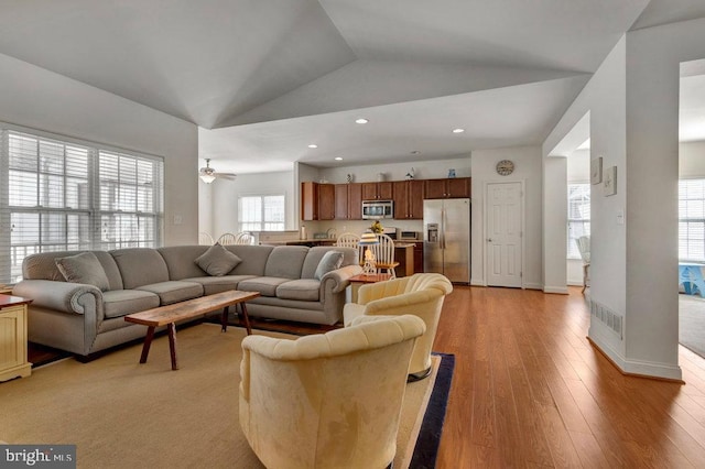 living room featuring lofted ceiling and light hardwood / wood-style flooring