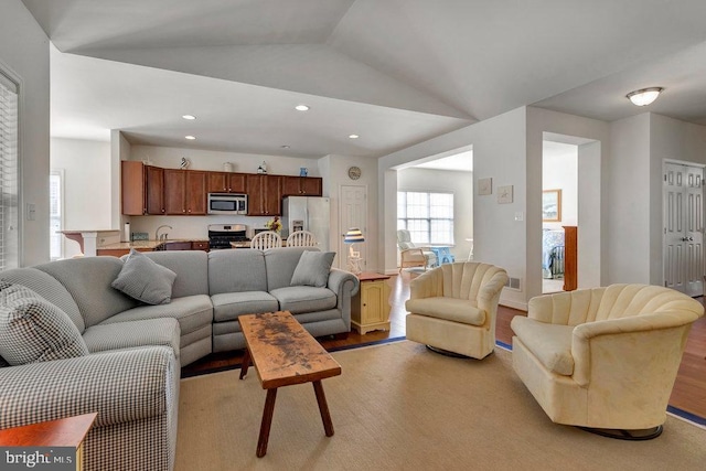 living room with lofted ceiling and light hardwood / wood-style flooring