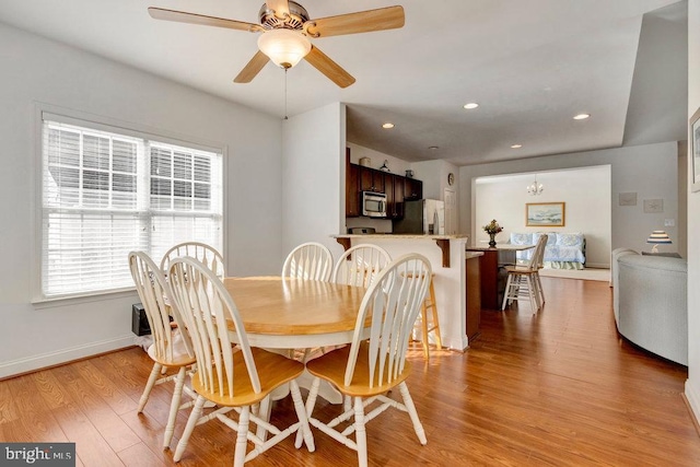 dining area with ceiling fan and light wood-type flooring