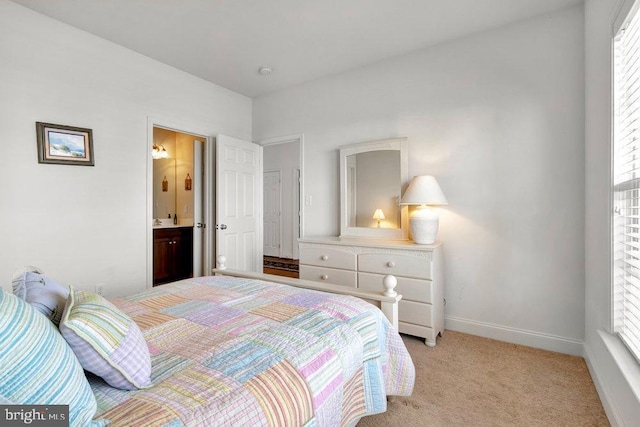 bedroom featuring light colored carpet and ensuite bath