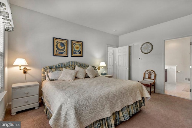 carpeted bedroom featuring ensuite bathroom