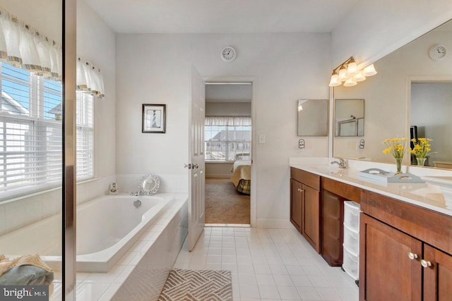 bathroom with tile patterned flooring, vanity, and tiled bath