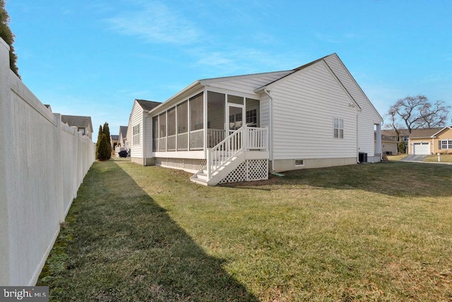 view of side of home with central AC unit, a lawn, and a sunroom