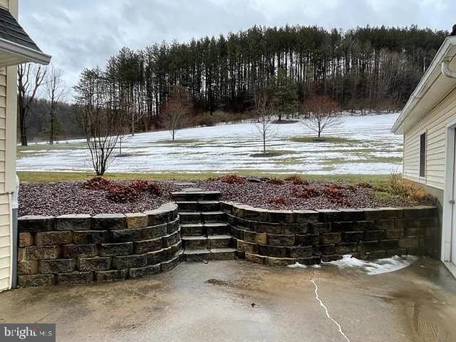 snowy yard featuring a patio