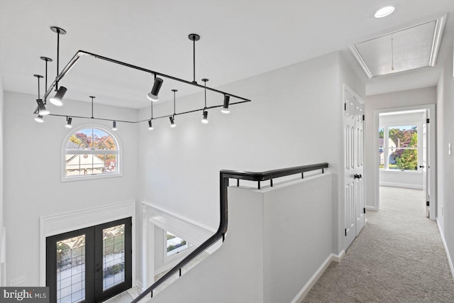 hallway featuring light colored carpet, track lighting, and french doors