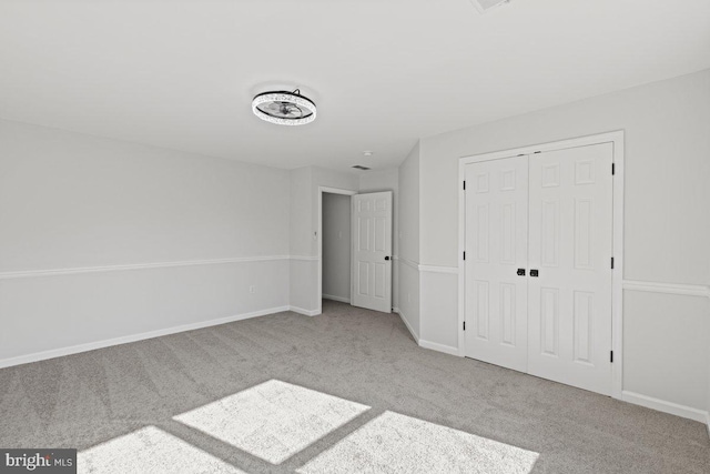 unfurnished bedroom with light carpet and a closet