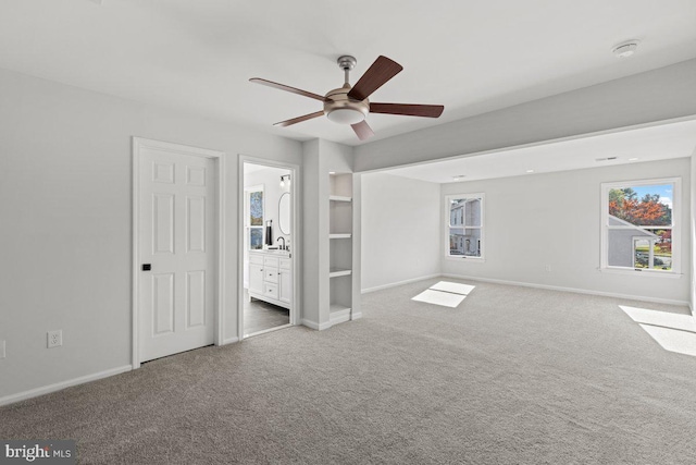 interior space featuring a wealth of natural light, ceiling fan, and carpet