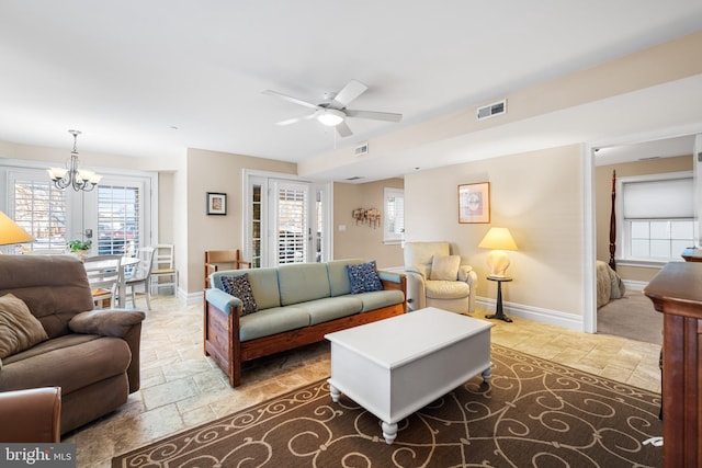 living room with ceiling fan with notable chandelier