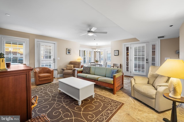 living room featuring ceiling fan with notable chandelier