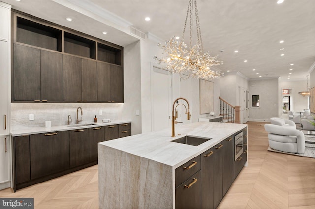 kitchen featuring a large island, sink, crown molding, and light parquet floors