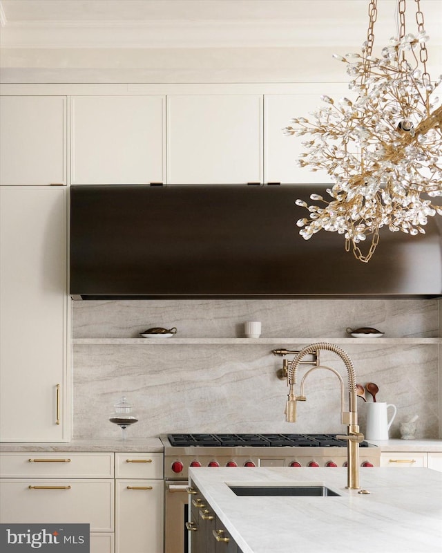 room details featuring sink, white cabinetry, hanging light fixtures, light stone countertops, and decorative backsplash