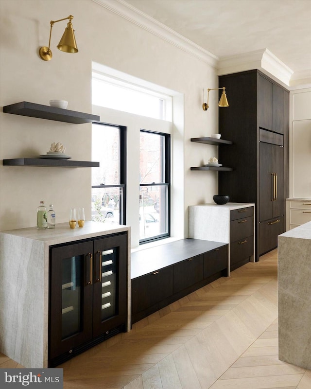 bar featuring ornamental molding, paneled built in fridge, and light parquet floors