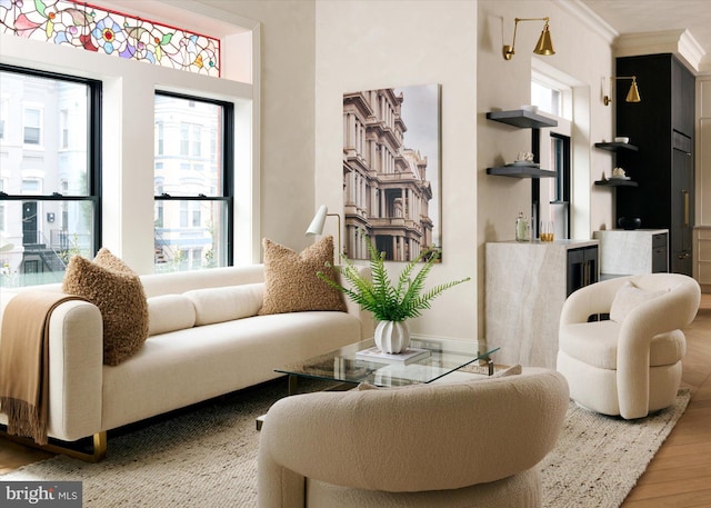 sitting room with hardwood / wood-style flooring, ornamental molding, and plenty of natural light