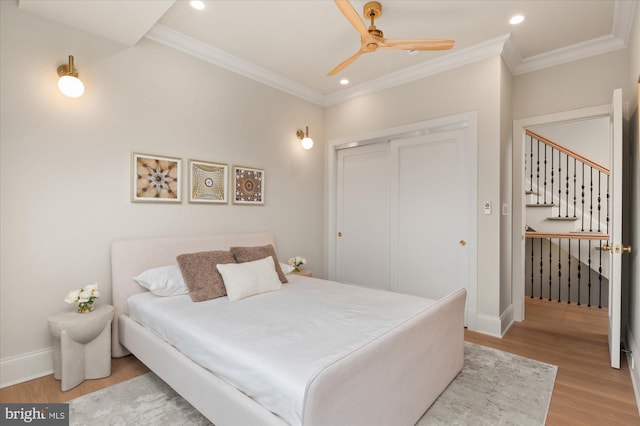 bedroom with crown molding, light hardwood / wood-style flooring, a closet, and ceiling fan