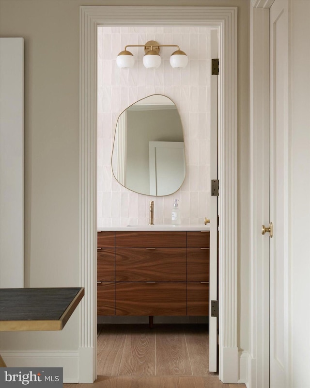 bathroom featuring vanity and tasteful backsplash