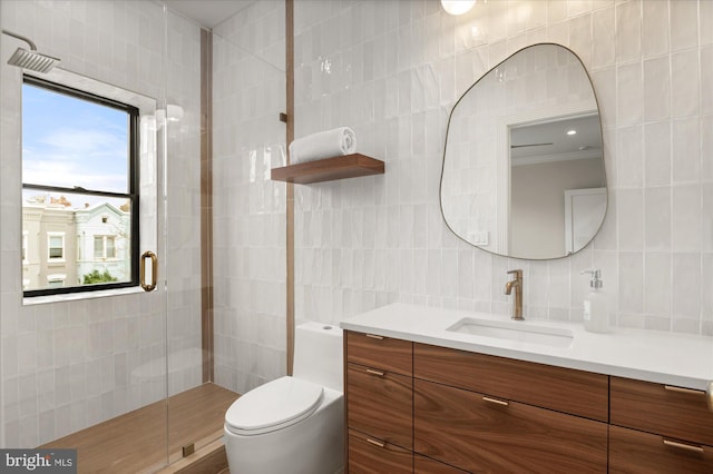 bathroom featuring walk in shower, toilet, tile walls, vanity, and backsplash