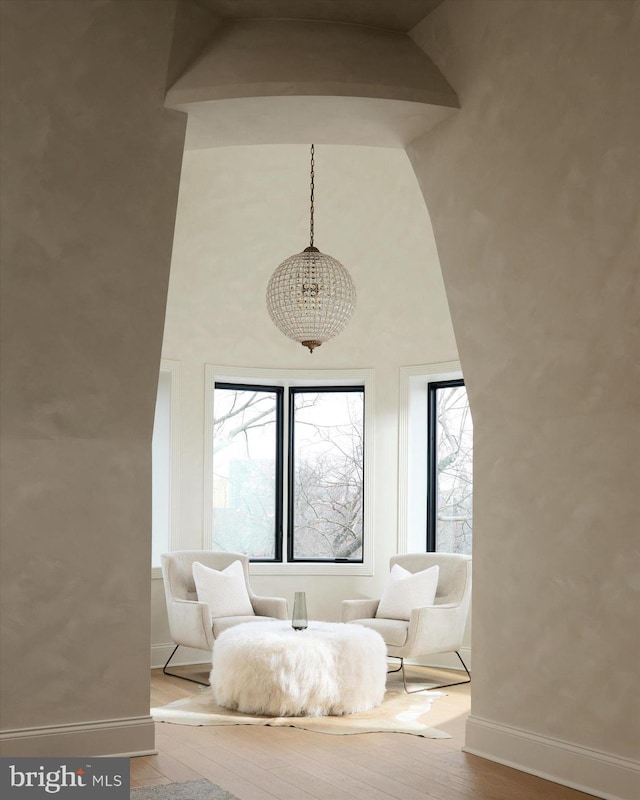 living area with wood-type flooring and high vaulted ceiling