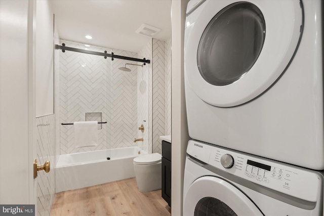 washroom featuring stacked washer / dryer and light wood-type flooring