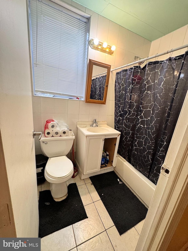 full bathroom featuring tile patterned floors, toilet, tile walls, vanity, and shower / bath combo with shower curtain