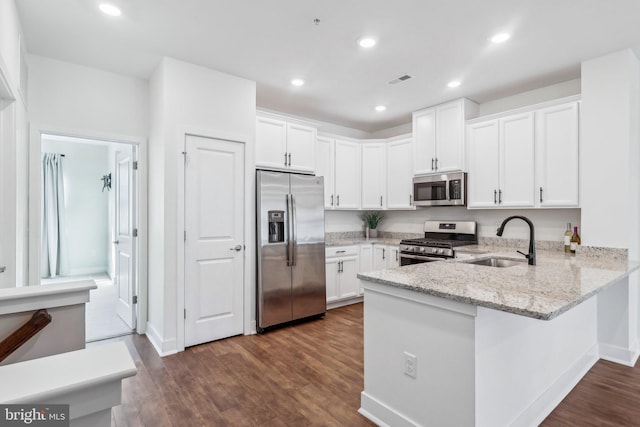 kitchen with stainless steel appliances, sink, and white cabinets